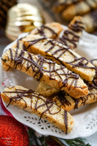 A white serving plate with a pile of Chocolate Almond Biscotti stacked on top. 