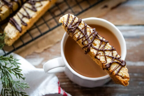A Chocolate Almond Biscotti Cookie resting on a cup of coffee. 