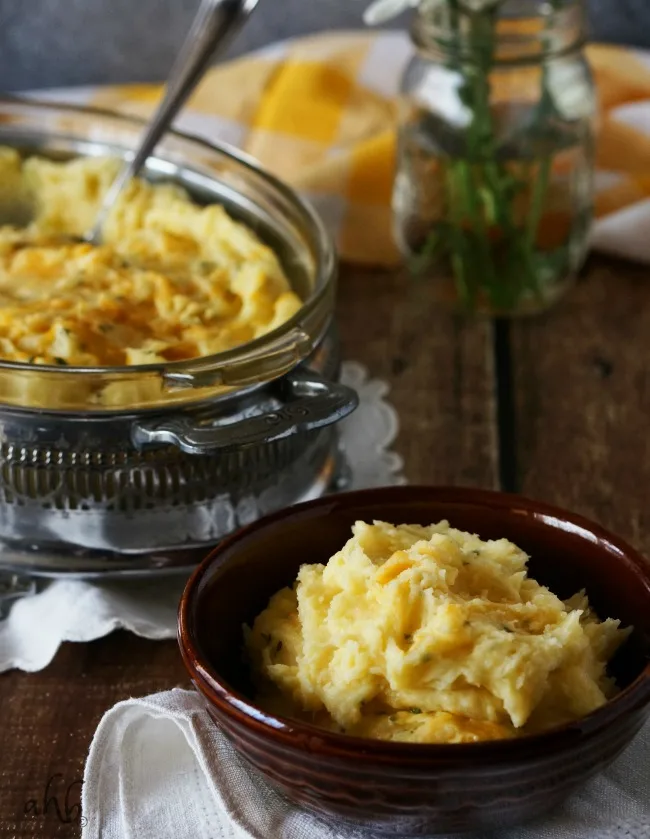 Creamy and fluffy mashed potatoes are taken to the next level of delicious with the addition of sharp cheddar cheese for a side dish everyone will love. Recipe on www.accidentalhappybaker.com @AHBamy