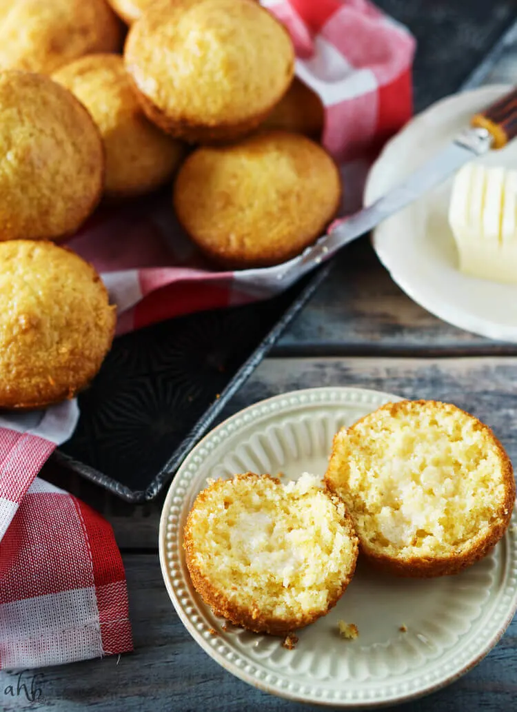A cornbread muffin sliced with melted butter in the center. 