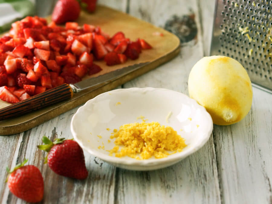 A bowl of lemon zest and chopped strawberries.