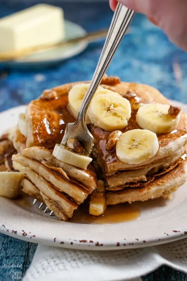 Several layers of banana pancakes speared on the end of a fork. 