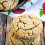 A stack of two cookies sitting in front of a plate of french toast cookies.