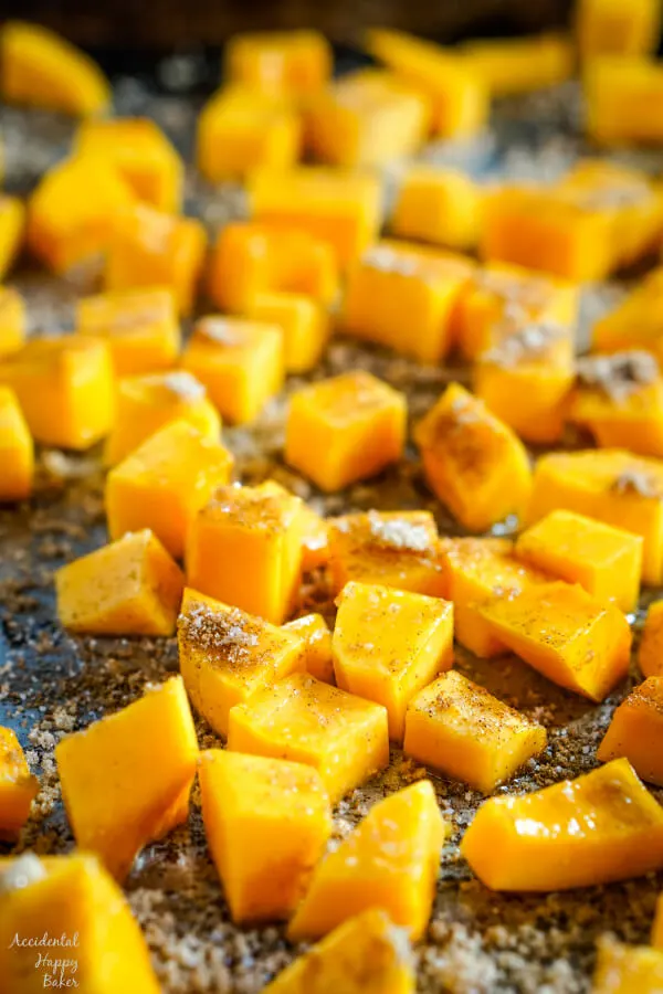A close up of butternut squash that has been sprinkled with cinnamon, salt and brown sugar. 