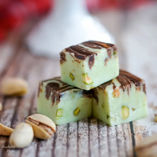 A close up image of 3 pieces of Pistachio swirl fudge that show the chopped pistachios inside the fudge. 