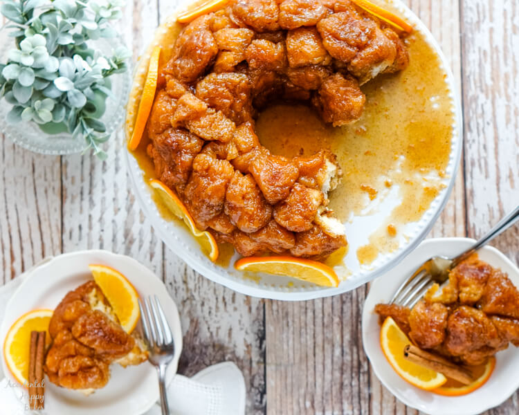 A large serving plate of Orange Spiced Monkey Bread and 2 small plates with servings. 
