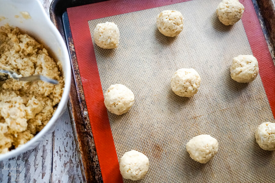 A sheet pan full of cookie dough that's been rolled into balls and is ready to bake. 