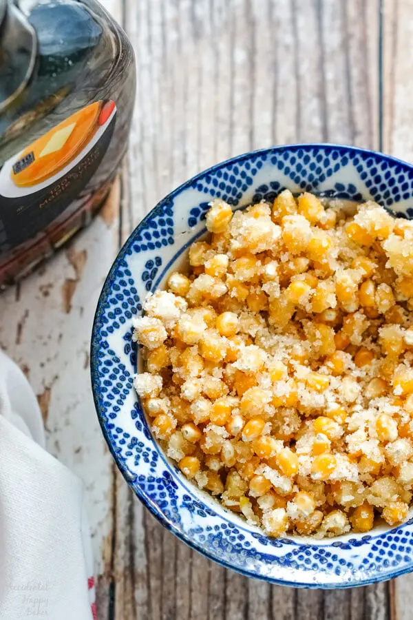 Popcorn kernels are mixed with sugar, and maple syrup before being added to the Dutch oven. 