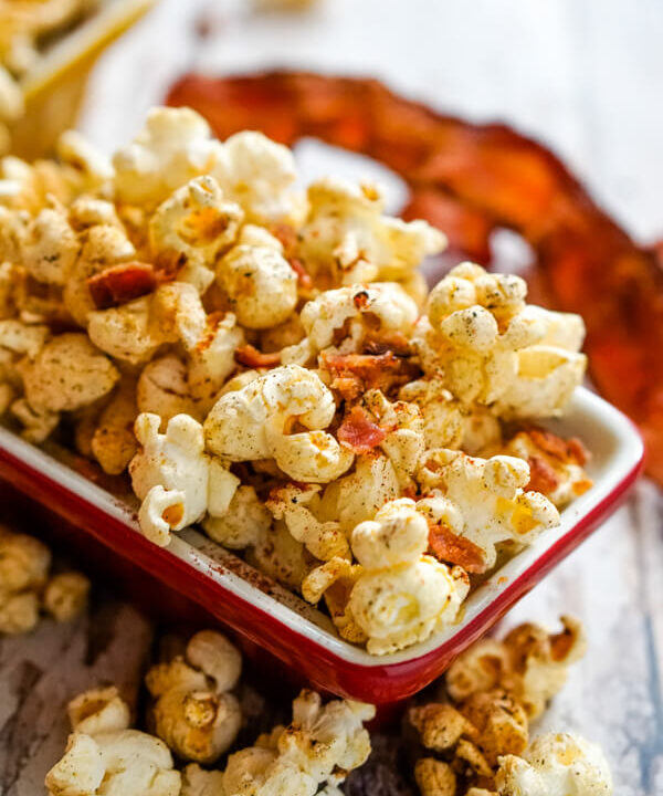 A red bowl full of smoky bacon popcorn.