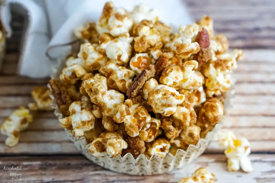A paper cup with a serving of Salted Caramel Pecan Popcorn