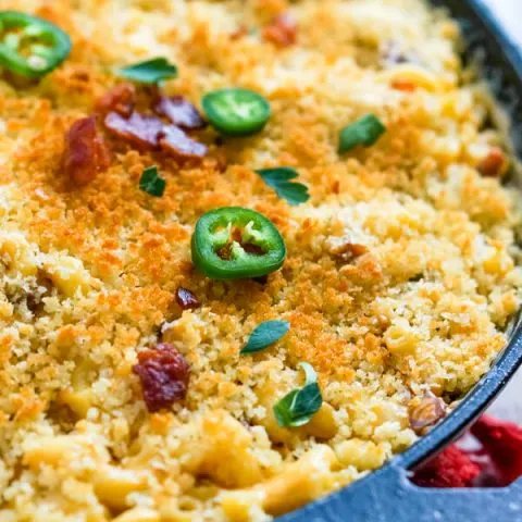 A close up image that shows the browned bread crumbs, bacon and jalapenos topping the macaroni and cheese.
