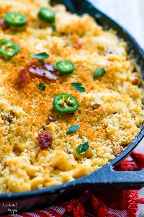 A close up image that shows the browned bread crumbs, bacon and jalapenos topping the macaroni and cheese. 