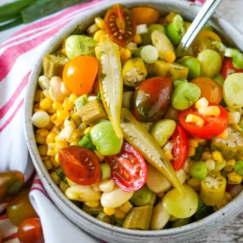 A bowl of Succotash Salad accented with slices of pickled okra.