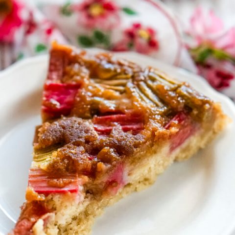 A slice of rhubarb ginger upside down cake on a white plate.