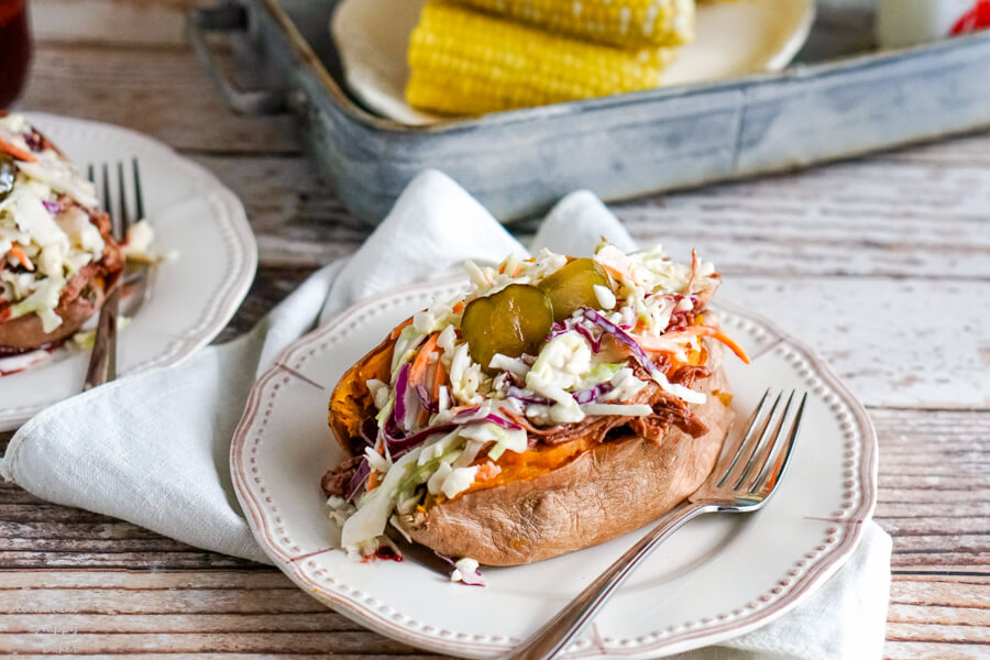 A baked sweet potato loaded with coleslaw and bbq chicken. 