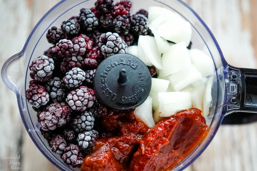 Blackberries, onion, and chipotle peppers are added to the food processor.