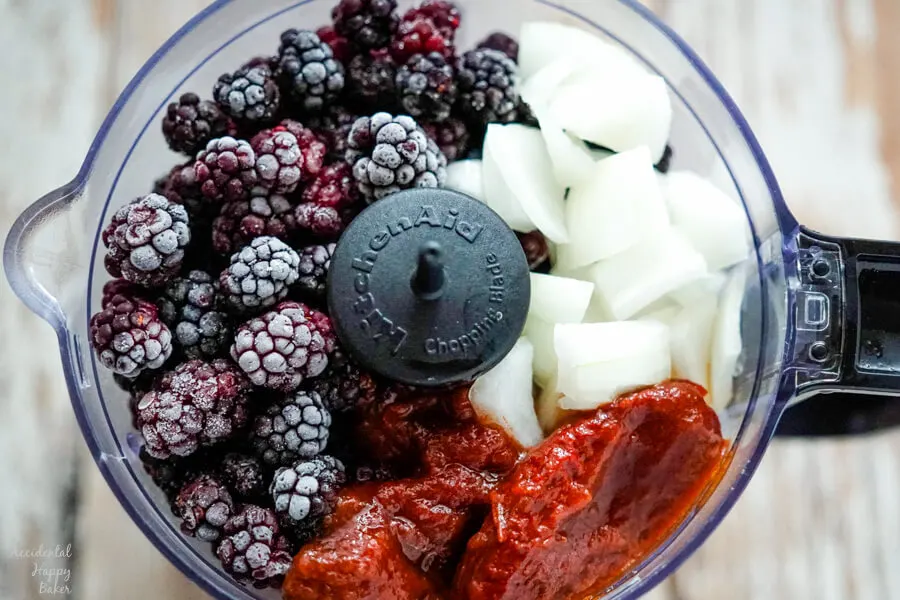 Blackberries, onion, and chipotle peppers are added to the food processor.