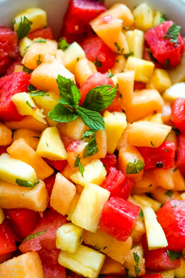 A close up image of watermelon fruit salad that shows the blend of watermelon, cantaloupe, pineapple, and fresh mint. 
