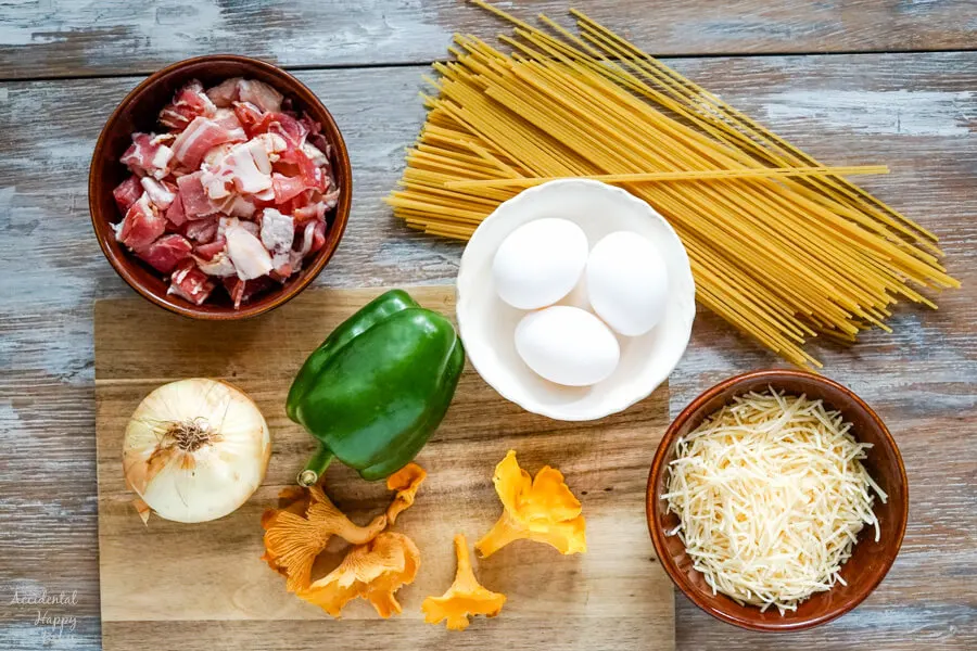 The ingredients for Spaghetti Carbonara. Bacon, pasta, onion, green pepper, eggs, parmesan cheese and mushrooms. 