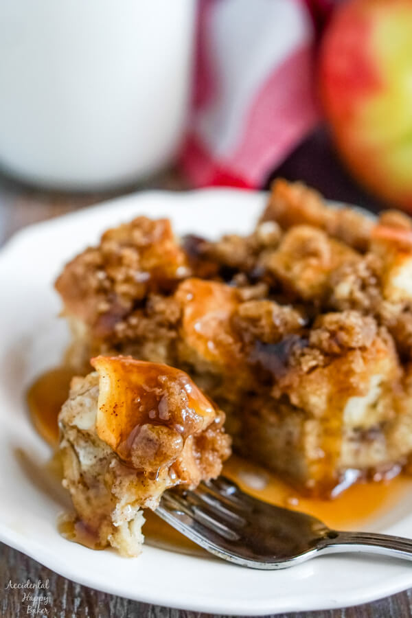 A close up image of a bite of french toast casserole dripping with syrup. 