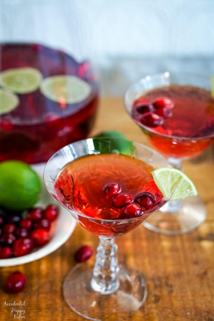 A glass of cranberry moscato punch on a wooden serving tray. 