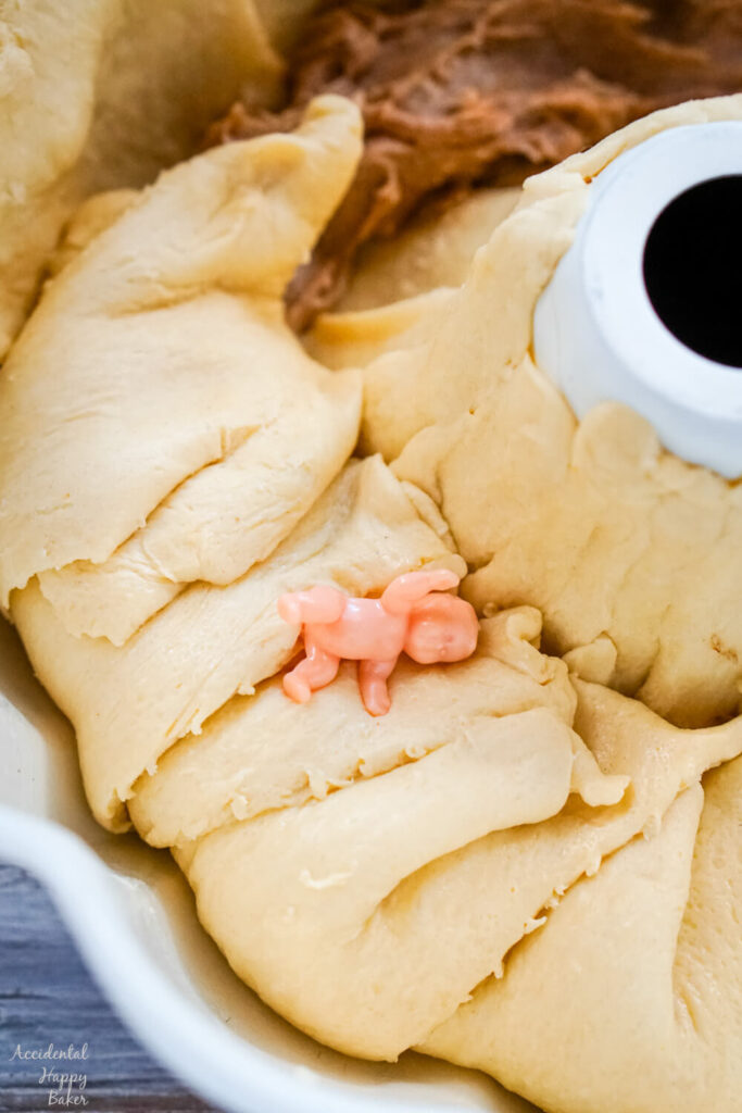 The crescent rolls are folded over the filling and the baby trinket is tucked between the layers of the rolls. 