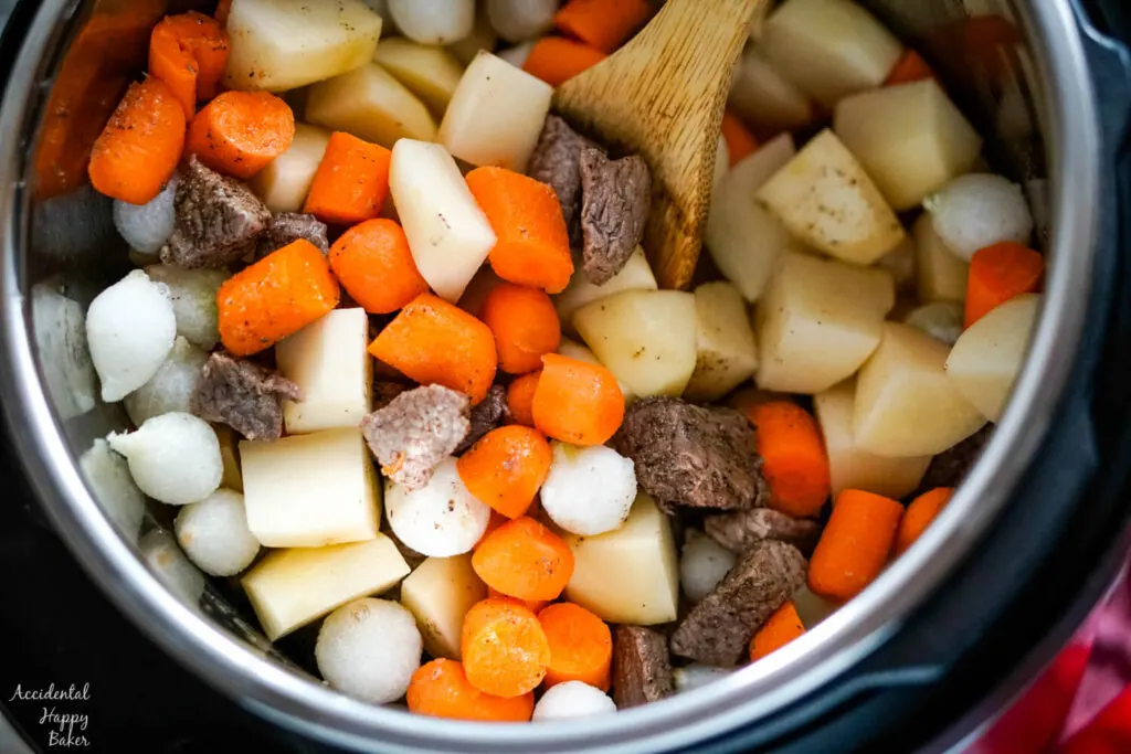 Potatoes, carrots, and pearl onions are added to the instant pot. 