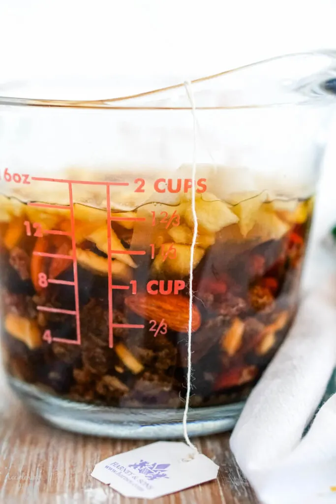 The dried fruit and tea steep together in the boiling water. 