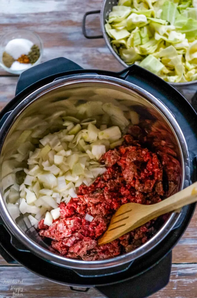 Ground beef is browned with onion and garlic in the instant pot. 