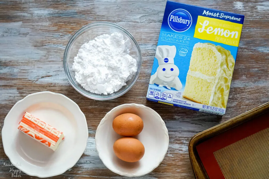 The ingredients needed for the recipe: butter, powdered sugar, eggs, and a box of lemon cake mix. 