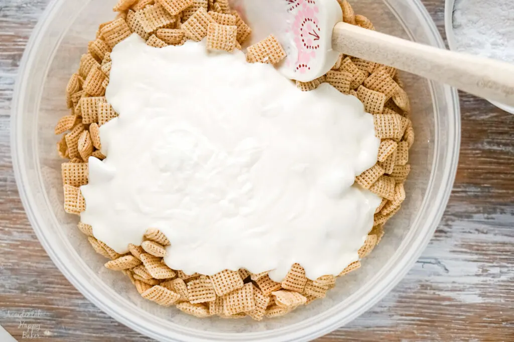 A bowl of chex cereal with melted almond bark poured over it. 