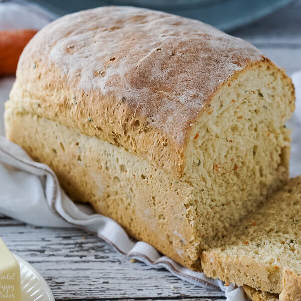 A loaf of carrot and chive bread that has just been sliced.