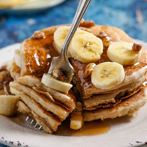 Several layers of banana pancakes speared on the end of a fork.