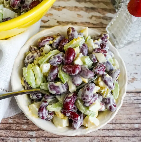 A serving of kidney bean salad in a white bowl.