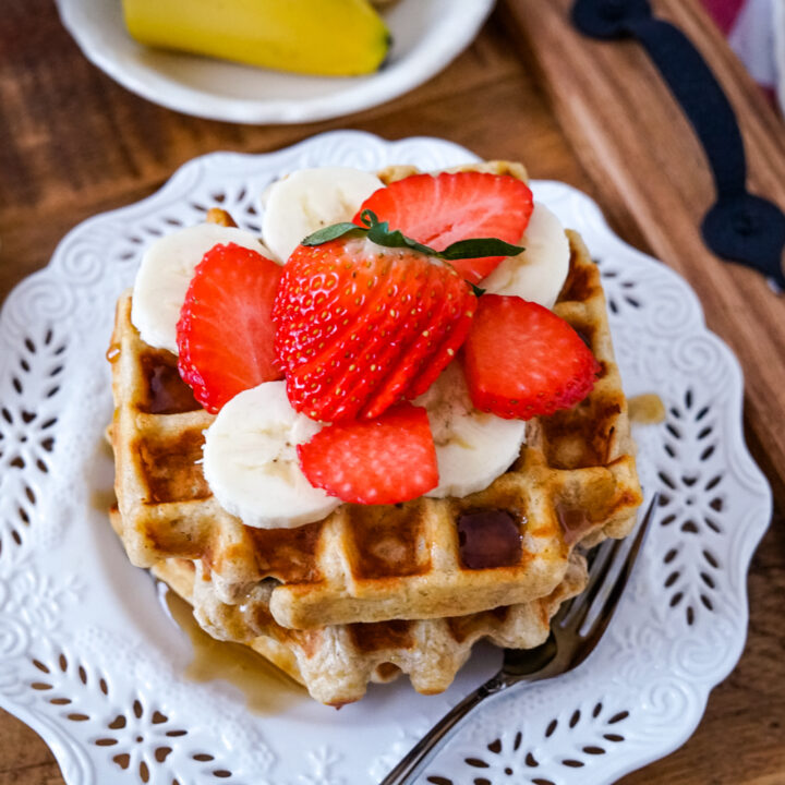 A stack of oatmeal waffles on a white plate.