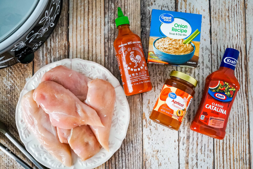 The ingredients needed to make Catalina Chicken: chicken breasts, Catalina dressing, apricot preserves, onion soup mix, and sriracha sauce