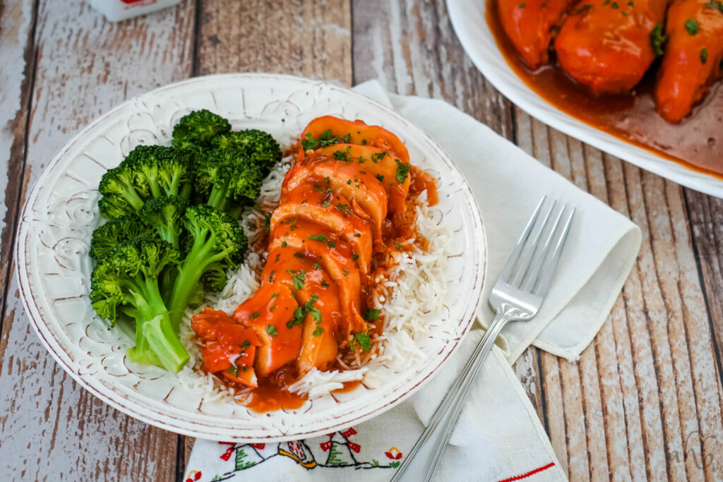 A serving of catalina chicken with rice and broccoli on a white plate. 