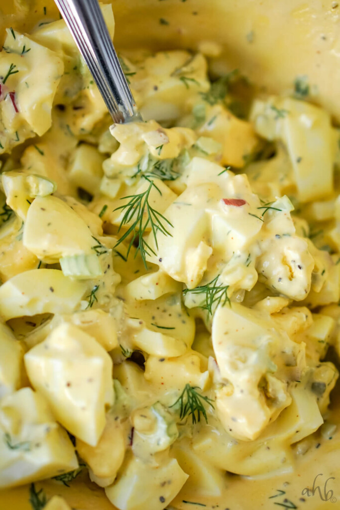 A close up image of a bowl of homestyle egg salad.
