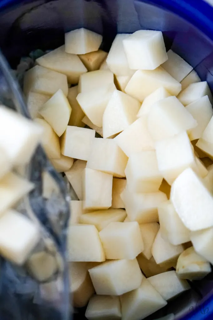 Peeled and cut potatoes are added to the stockpot and covered with water.