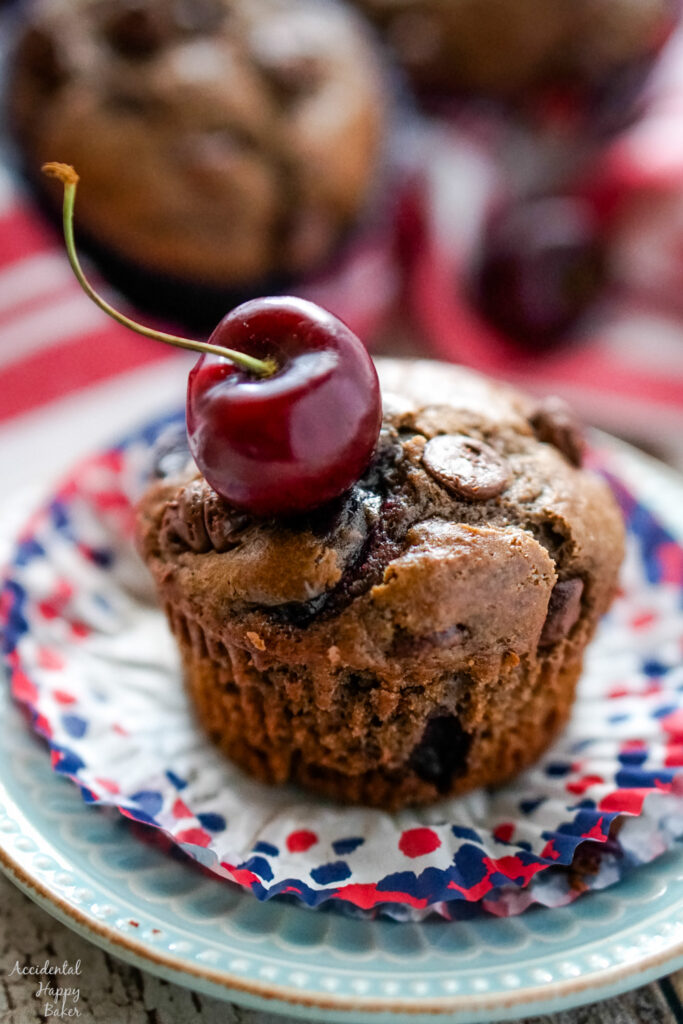 An unwrapped Cherry Chocolate muffin topped with a fresh cherry.