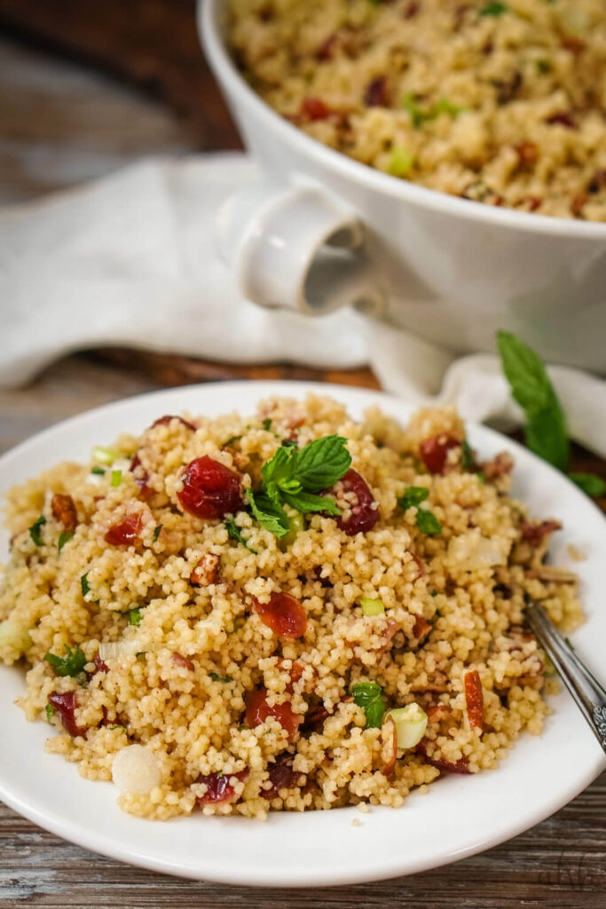 A serving of cranberry couscous salad on a white plate.