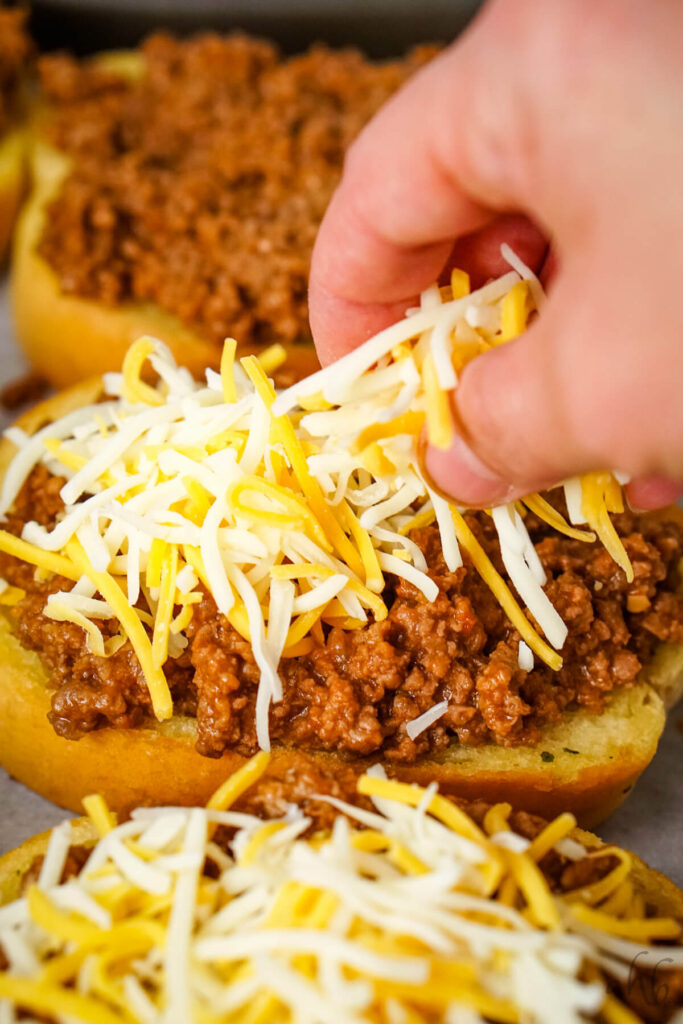 Shredded colby jack cheese is added to the garlic bread and meat mixture.