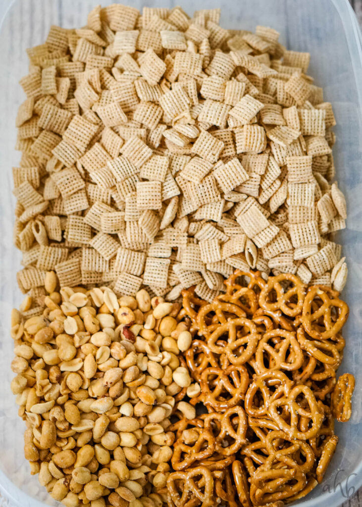 Peanuts, pretzels, and Chex cereal in a microwavable bowl.