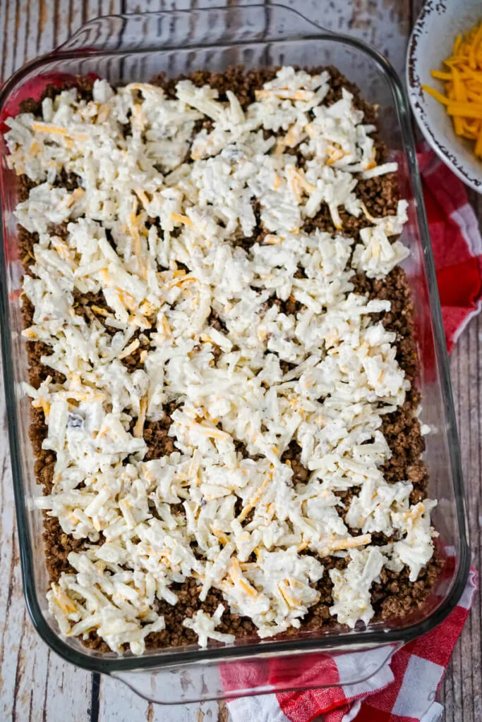 Spoonfuls of the remaining potato mixture have been added on top of the ground beef.