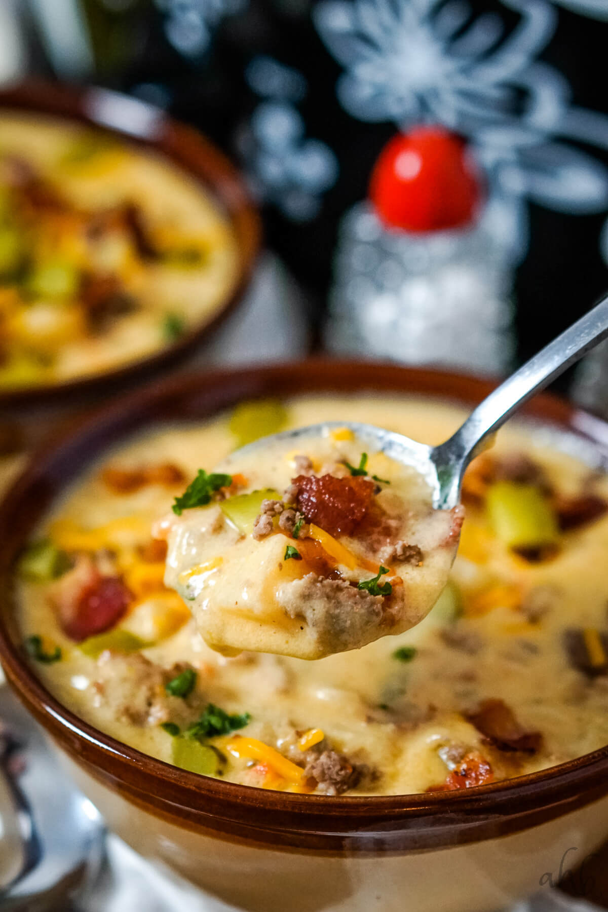 A close up image of a spoon full of slow cooker bacon cheeseburger soup.