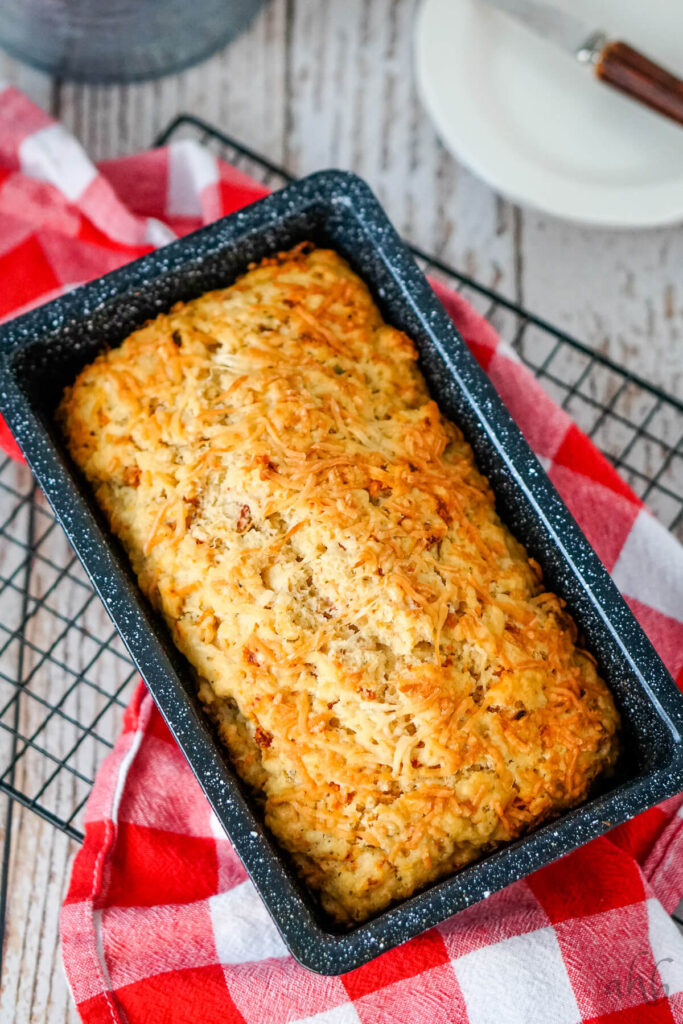 A loaf of Sun Dried Tomato and Parmesan Beer Bread is cooled in the pan.