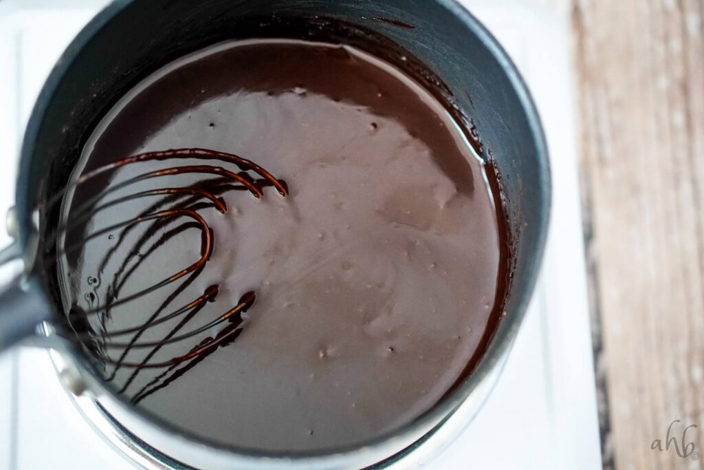 The melted chocolate syrup is stirred with a whisk. 