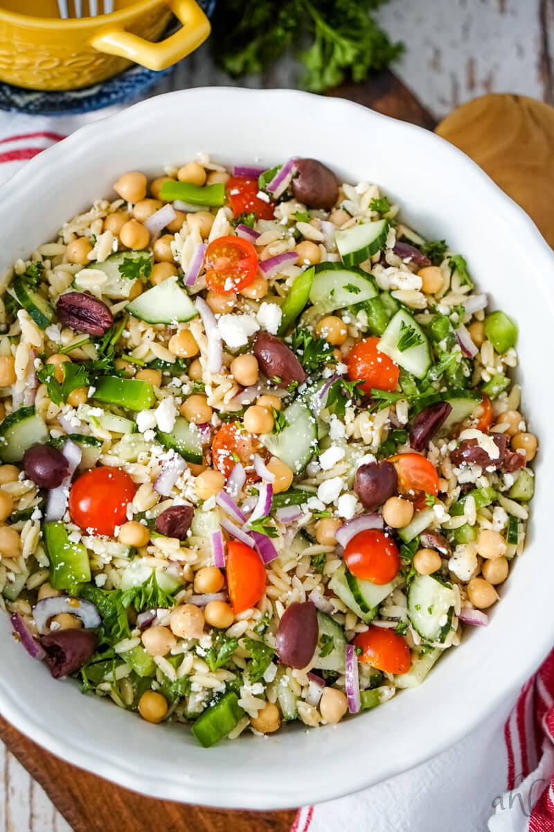 The tossed and finished Orzo Garbanzo Bean Salad in a white bowl.