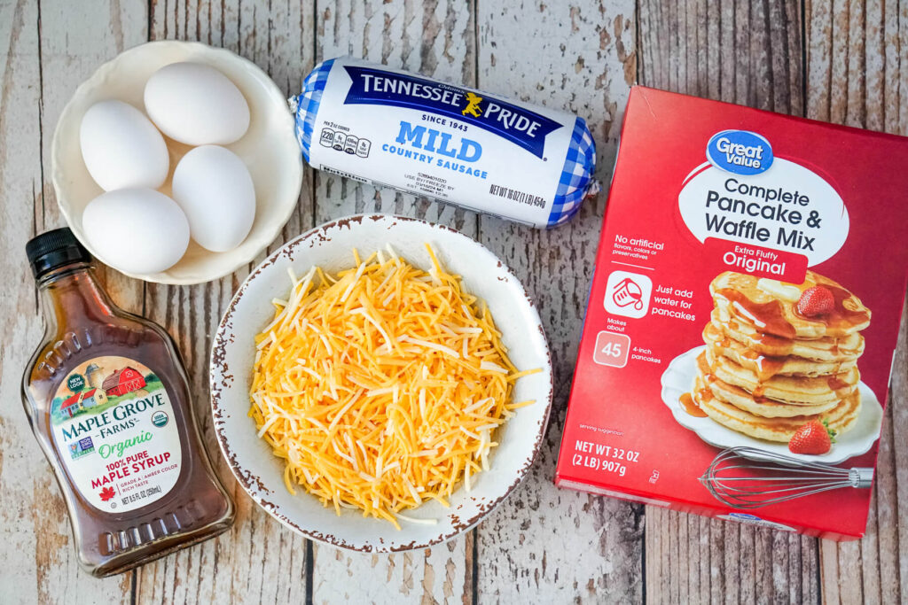 The ingredients needed to make mcgriddle muffins: maple syrup, eggs, sausage, cheese and pancake mix. 
